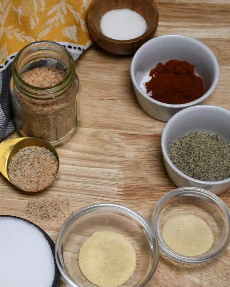 A small jar and all the ingredients that is needed to make homemade seasoning salt.