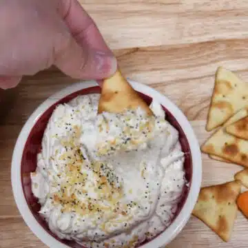 Creamy and savory bagel seasoning dip on a pita chip.
