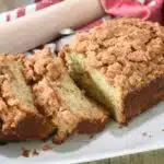 Sliced banana bread with crumb topping on a platter.