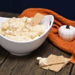 Front view of the pumpkin dip in a bowl with graham crackers.
