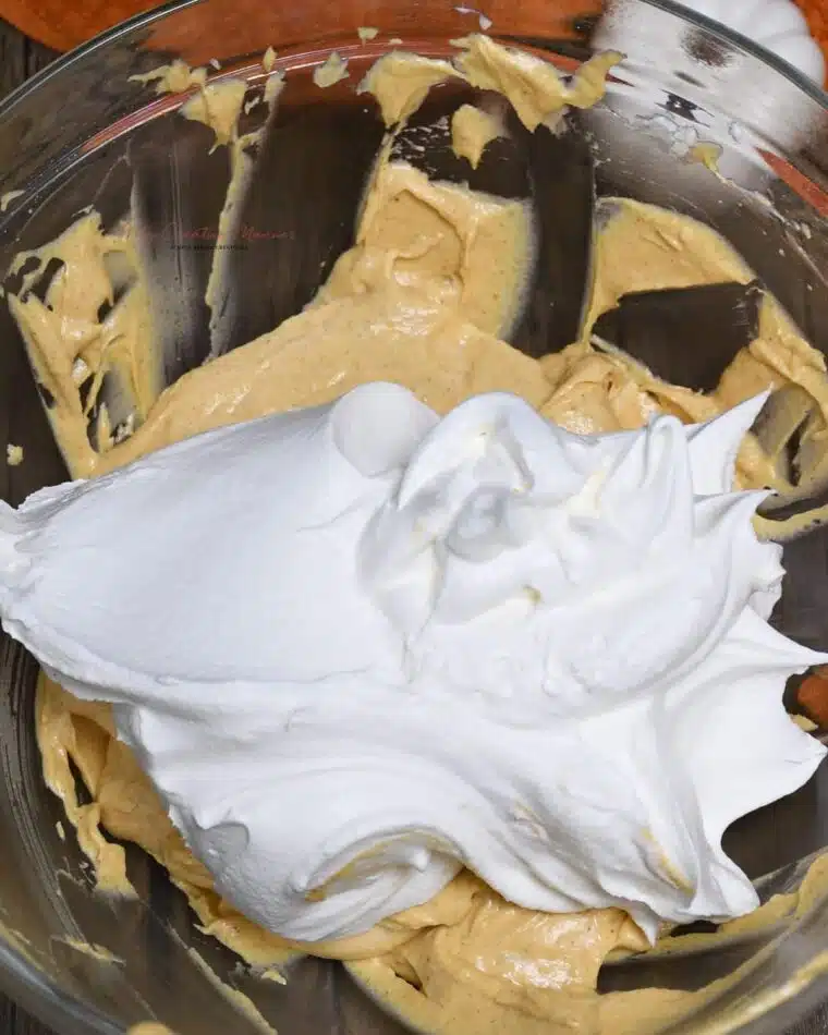 A bowl with with cool whip thats on top of the pumpkin mixture.