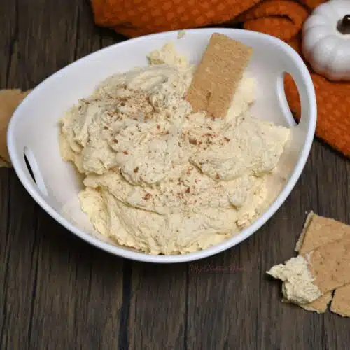 Overhead image of a bowl filled with pumpkin cream cheese dip recipe with graham crackers.