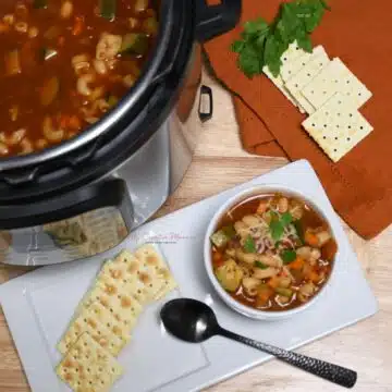 Overhead image of a Instant Pot that is full of the soup and a bowl that is filled with minestrone soup.
