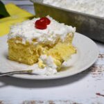 A closeup of the poke cake on a plate with some on the fork.