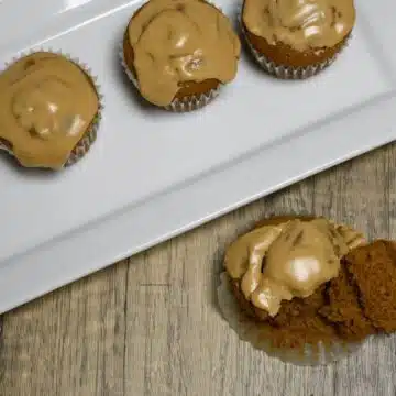 Overhead image of muffins on a plate and one that has been split in half.
