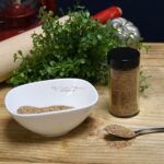A spoon, bowl, and a spice jar that has the Southwest spice blend in them.