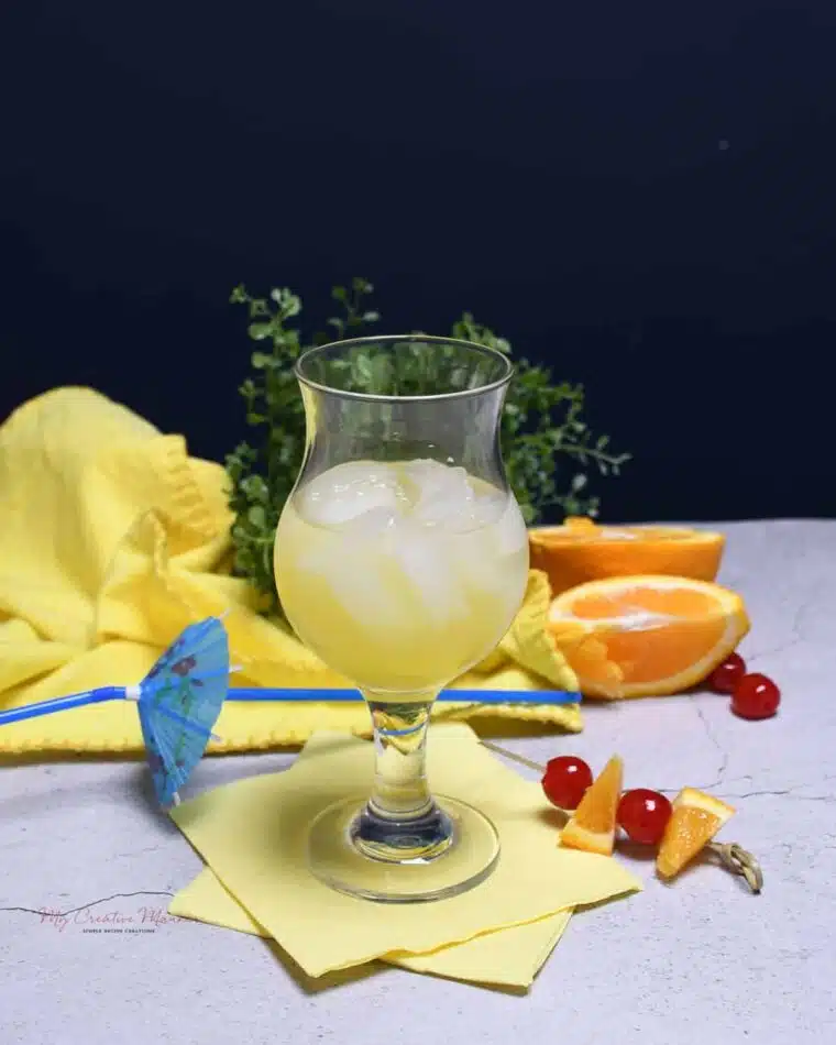 A glass that has ice, Malibu rum, and pineapple juice in it.