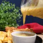 Spicy mustard sauce dripping out of a mason jar.
