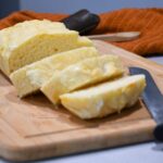 The front of a loaf of homemade bread that was made with 2 ingredients that has been sliced.