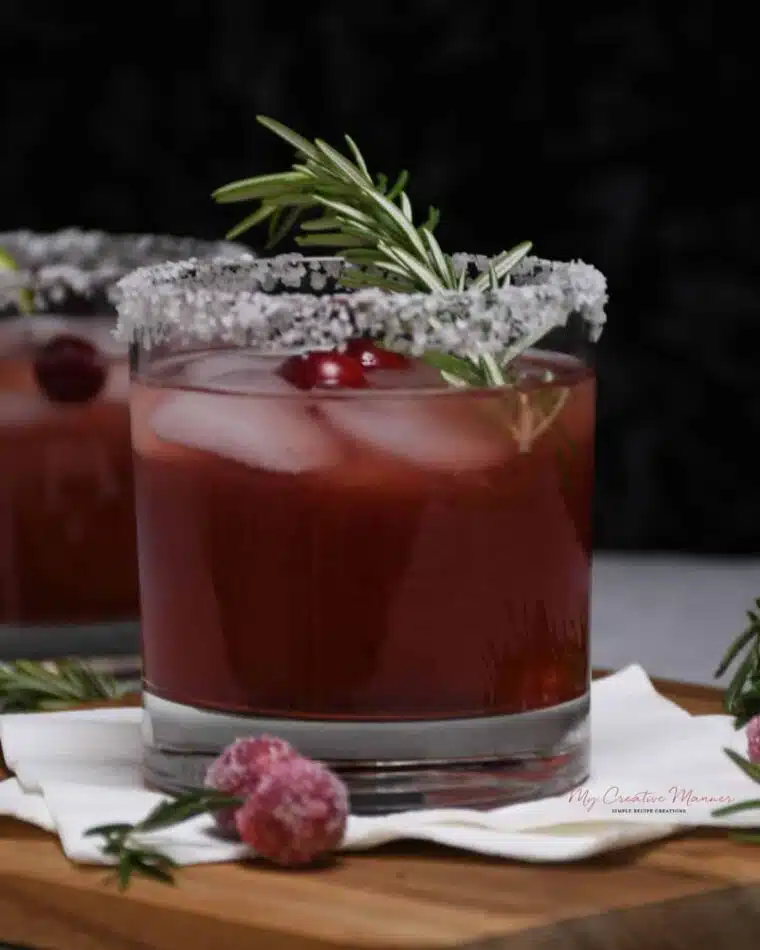 A margarita that is flavored with cranberry juice in a cocktail glass.