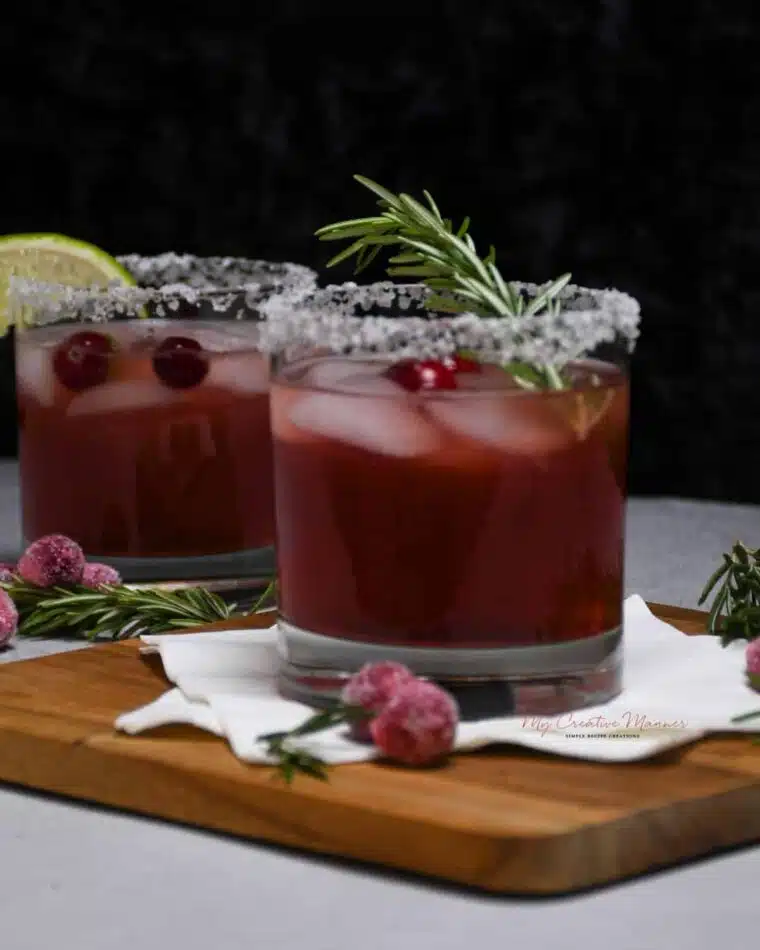 Two cocktail glasses filled with seasonal margarita mix of cranberry juice and tequila.