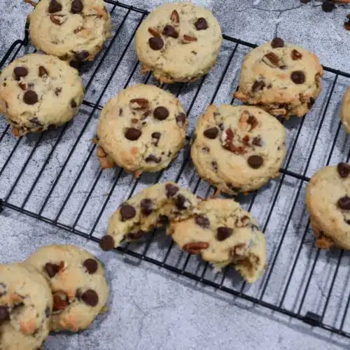 Overhead image of a cooling rack with chocolate chip coconut pecan cookies on it.