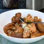 Close up of a bowl filled with the chicken and potato casserole that is made in a slow cooker.