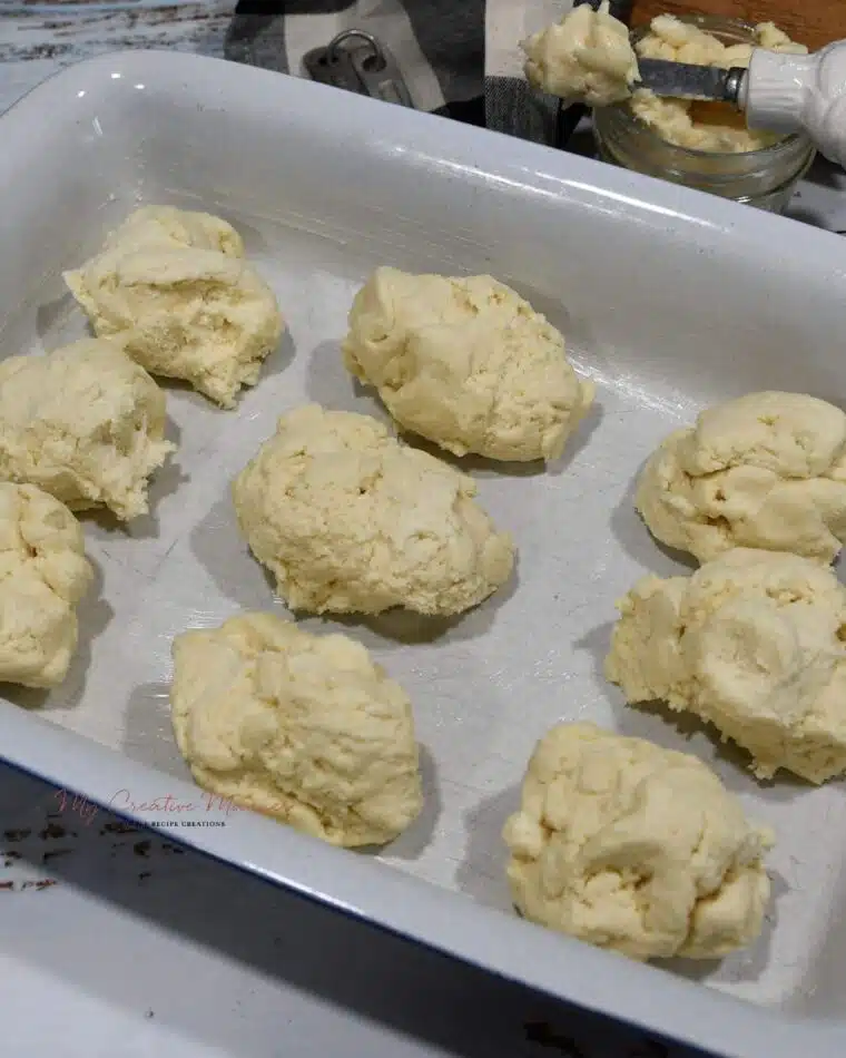 A baking dish with the unbaked biscuits in it.