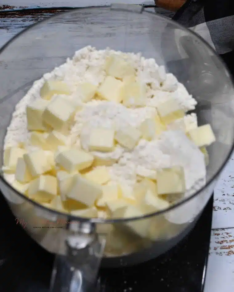 A food processor with self rising flour and butter cubes.