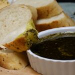 A slice of bread with the olive oil bread dip on it.