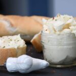 A close up of a jar that is filled with whipped honey butter.