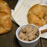 Croissants behind a small bowl that is filled with the brown sugar cinnamon butter spread.