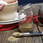 A close up of a jar filled with the blended homemade poultry seasoning in.