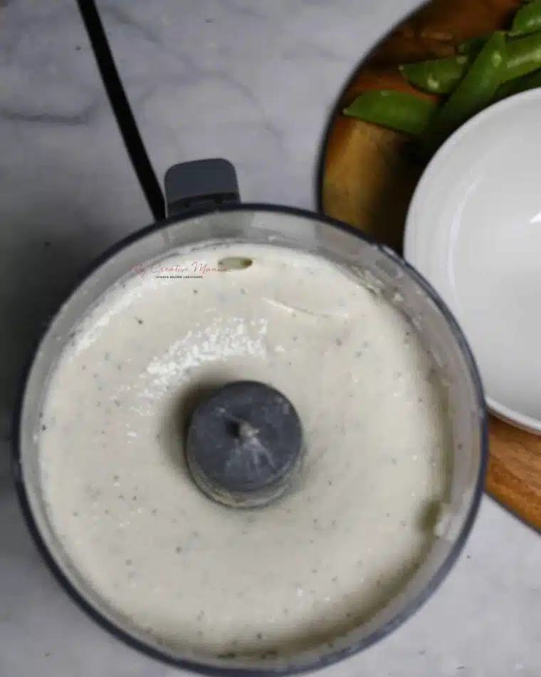 Overhead image of a mini food processor that has the creamy cottage cheese ranch dip in it.
