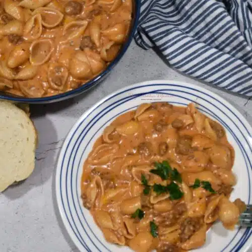 Overhead view of a plate and bowl that have the creamy beef and shells recipe on it.