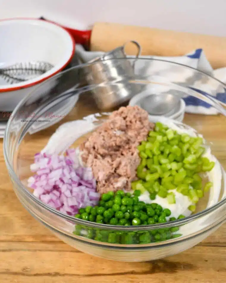 Tuna, peas, red onion, and celery in teh Greek yogurt mayo dressing for this cold pasta salad.
