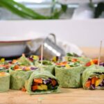 A cutting board that is filled with the rainbow veggie pinwheels.